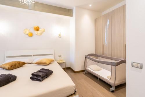 a white bedroom with a bed and a chair at Appartamento di Lusso in Centro - Freedom Gli Artisti in Bologna