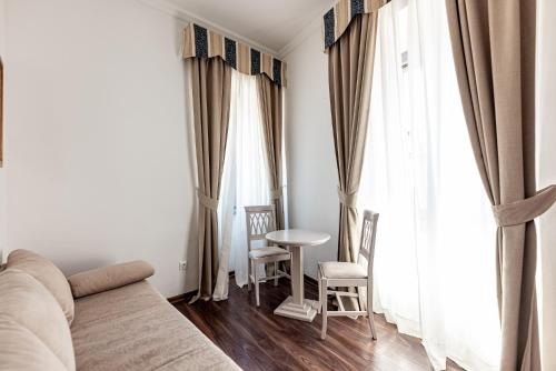 a living room with a couch and a table and windows at Boutique Hotel Kaštel in Motovun