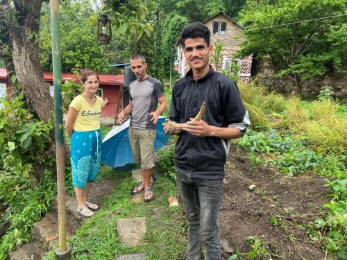 two men and a woman standing in a yard at Hamro Family Ghar Apartment or Room near Kathmandu in Kathmandu
