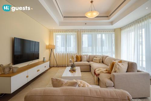 a living room with a couch and a flat screen tv at HiGuests - Elegant Family Retreat in Dubai's Deira 3BR Oasis in Dubai