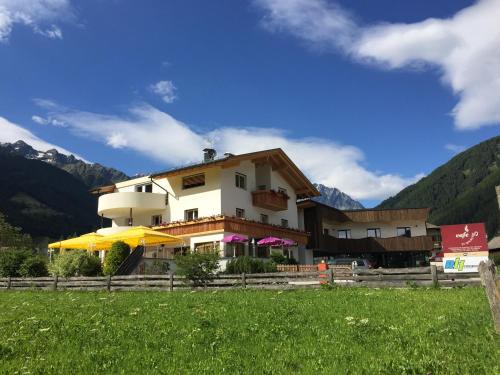 a building with a yellow umbrella in front of it at Apartments Sankt Walburg in Anterselva di Mezzo