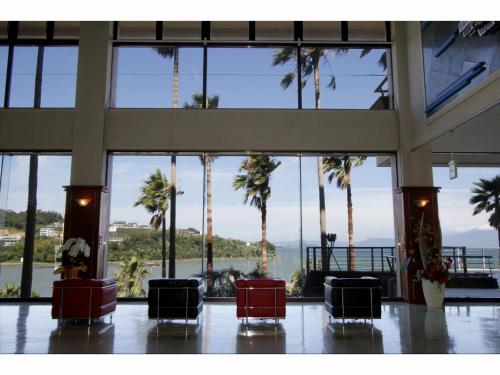 a lobby with palm trees and a view of the ocean at Hotel Alegria Gardens Amakusa - Vacation STAY 40454v in Amakusa