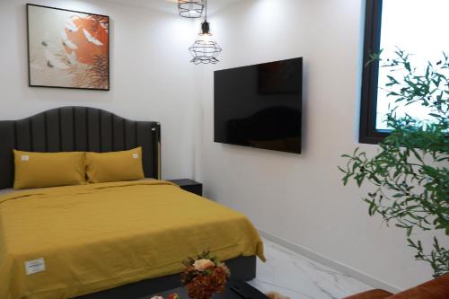 a bedroom with a bed with a yellow blanket at The Grand Diamond C Hotel in Trung Ðồng
