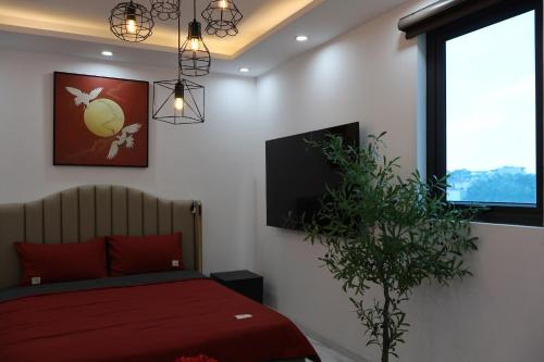 a bedroom with a red bed and a tv at The Grand Diamond C Hotel in Trung Ðồng