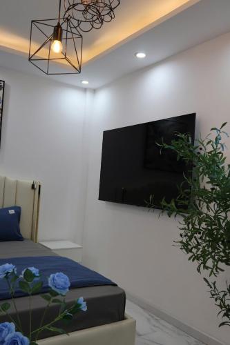 a bedroom with a flat screen tv on a wall at The Grand Diamond C Hotel in Trung Ðồng