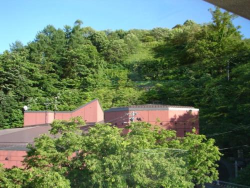 a building with trees in front of a mountain at Aeria Tohno - Vacation STAY 62232v in Tōno