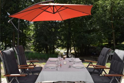 a table with a red umbrella and chairs at Sellinkoje in Ostseebad Sellin