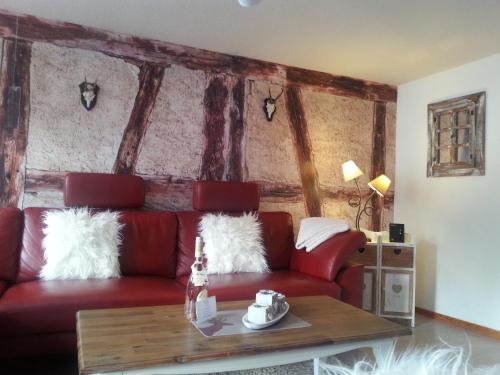 a living room with a red couch and a table at Ferienhaus Sankt Andreasberg in Sankt Andreasberg