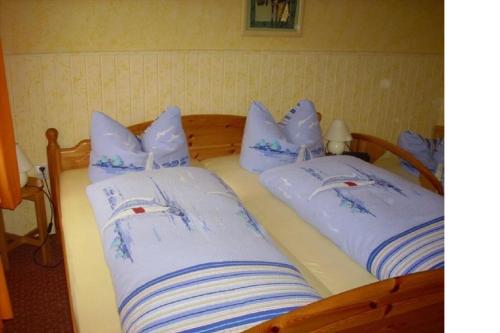 Bungalow Rose في لودين: سريران عليهما وسائد زرقاء وبيضاء