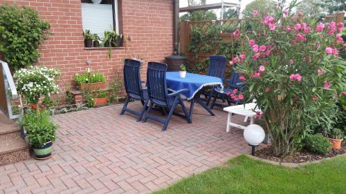 a patio with a blue table and chairs and flowers at Ferienwohnung Kerstin in Siggelkow