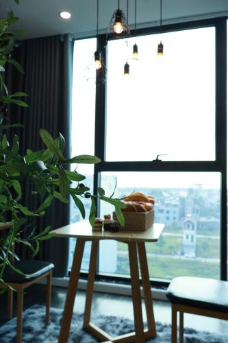 a table with a basket of bread on it in front of a window at The Grand Diamond C Hotel in Trung Ðồng