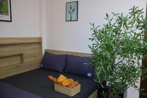 a basket of bread sitting on a couch next to a plant at The Grand Diamond C Hotel in Trung Ðồng