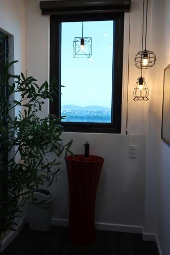 a window in a room with a plant and lights at The Grand Diamond C Hotel in Trung Ðồng