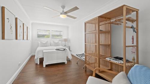 a white bedroom with a bed and a white table at Casa Bianca Accom Holidays in Copacabana