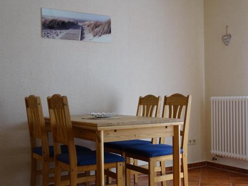 tavolo da pranzo con 4 sedie e una foto sul muro di Ferienwohnung Kienast 1 a Pudagla