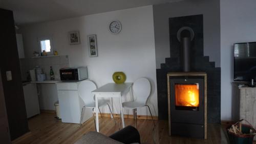 a living room with a fireplace and a stove at Ferienbungalow in Neuruppin