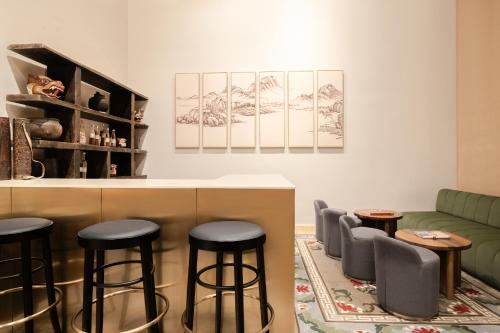 a bar with stools and a couch in a room at Zhiwaling Heritage in Paro