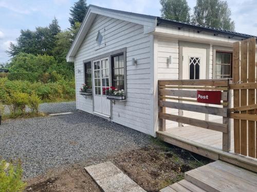 a small white shed with a wooden fence at Haby House in Skene