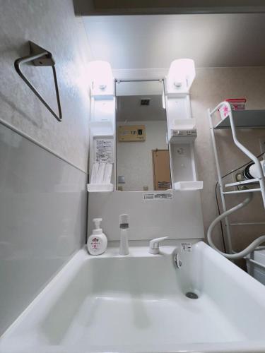 a bathroom with a white sink and a mirror at アーバンハイツ渡辺通a棟 in Fukuoka