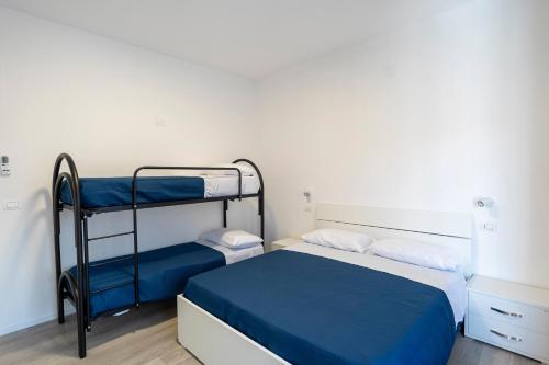 a bedroom with two bunk beds with blue sheets at Prestige House 8 in Scalea