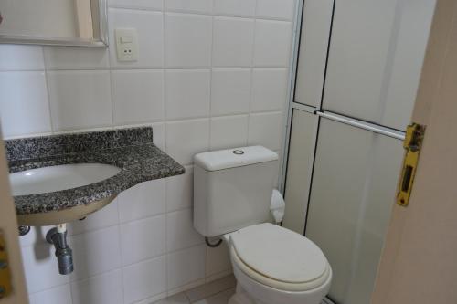 a small bathroom with a toilet and a sink at Apartamento Satel Praia in Itanhaém
