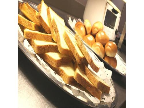 a tray filled with bread and some buns and tomatoes at Mount View Hotel - Vacation STAY 40103v in Kamikawa