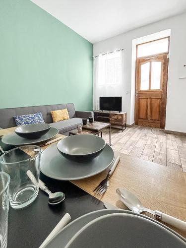 - un salon doté d'une table avec des assiettes et des ustensiles dans l'établissement Le Coeur de Melun, Chaleureux appartement, à Melun