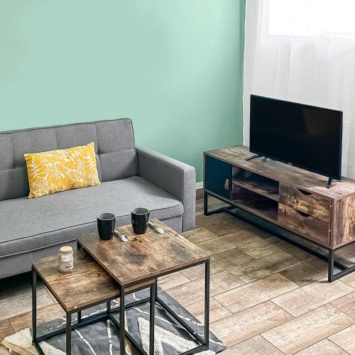 un salon avec un canapé et une télévision à écran plat dans l'établissement Le Coeur de Melun, Chaleureux appartement, à Melun