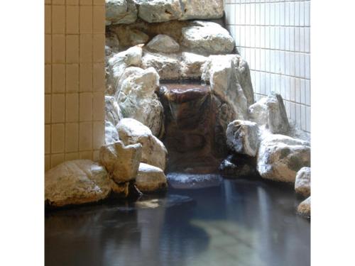 a water fountain in a building with rocks at Mount View Hotel - Vacation STAY 40103v in Kamikawa