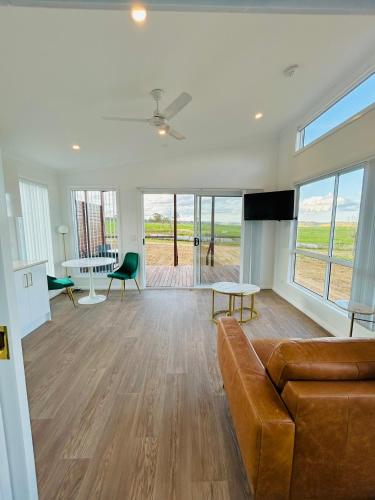 a living room with a couch and a flat screen tv at Red Hill Cabin #1 Walcha in Walcha