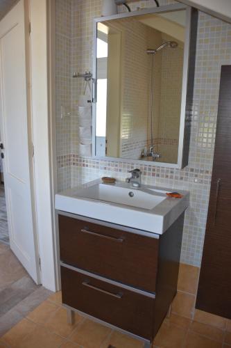 un baño con lavabo y espejo en Villa Gerani, en Gerani
