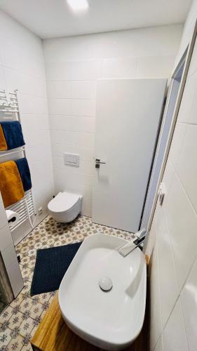 a white bathroom with a toilet and a sink at Četnická Stanice Mšeno in Mšeno