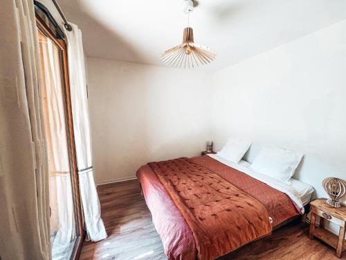 une chambre avec un lit et une grande fenêtre dans l'établissement La Marmotte, Grand appartement avec terrasse, au Monêtier-les-Bains