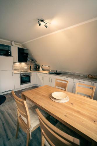 a kitchen with a wooden table and chairs at Haus Seeschwalbe - Wohnung 13 in Spiekeroog