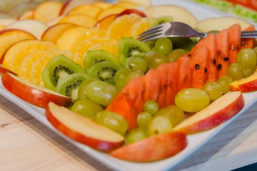 a plate of fruit on a table with a fork at Cap Hôtel in Noyelles-Godault