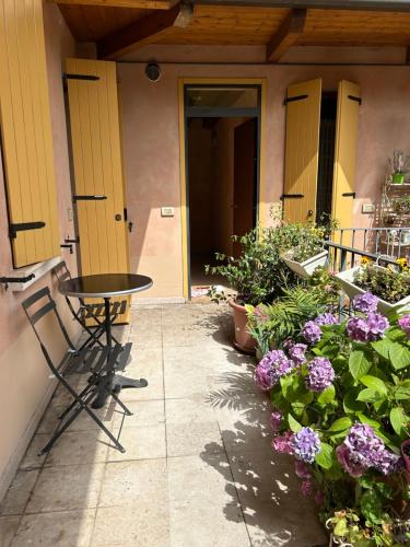 a patio with a table and some plants and flowers at Mirella house Desenzano del Garda -Centro storico, 30 mt dal lago in Desenzano del Garda