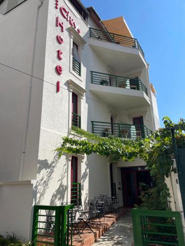 a white building with a sign on the side of it at City 5 Hotel in Tirana