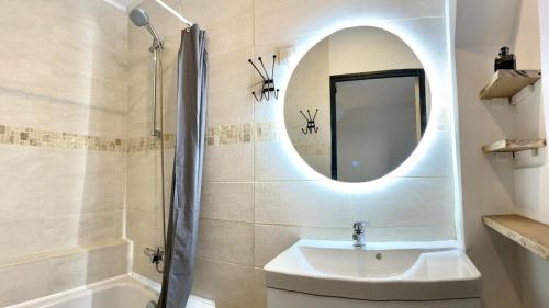 une salle de bain avec un lavabo et un miroir dans l'établissement La sérénité côtière, à Dinard