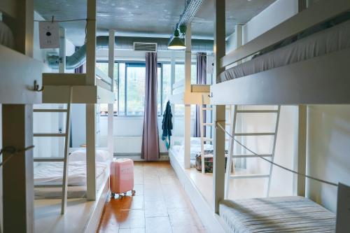 a dorm room with bunk beds and a pink suitcase at ClinkMama in Amsterdam