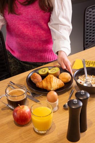 a woman standing at a table with a plate of food at Korner Saint Marcel in Paris