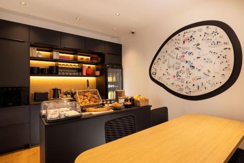 a kitchen with a table and a clock on the wall at Korner Saint Marcel in Paris