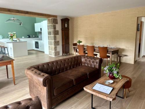 un salon avec un canapé marron et une table dans l'établissement Entre Rennes et St Malo, grande maison lumineuse Chez Mathilde, à Irodouër