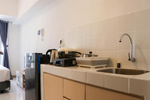 eine Küche mit Spüle und Mikrowelle in der Unterkunft Brand New Studio at Tokyo Riverside PIK 2 Apartment By Travelio in Rawalembang