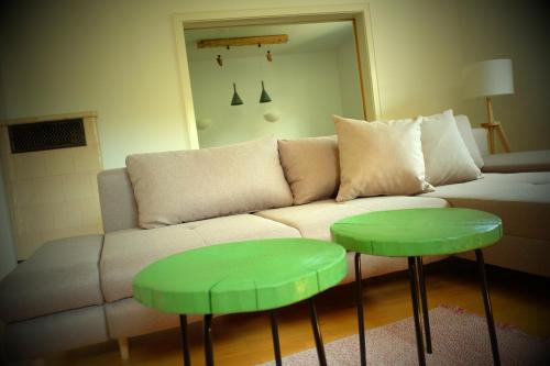 a living room with a couch and two green tables at Flößer-Heimat Wiesenblick in Baiersbronn