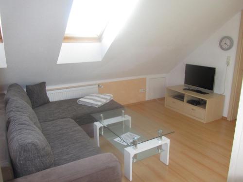 a living room with a couch and a tv at Ferienhaus Bolliger Apartment 3 in Kalkhorst
