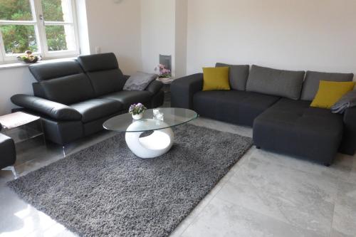 a living room with a couch and a table at Ferienwohnung am Grölisbach - Eifel in Roetgen