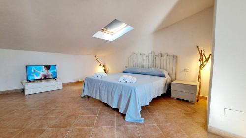 une chambre avec un lit et une télévision à écran plat dans l'établissement Follow The Sun Casa fronte mare, à Portoscuso