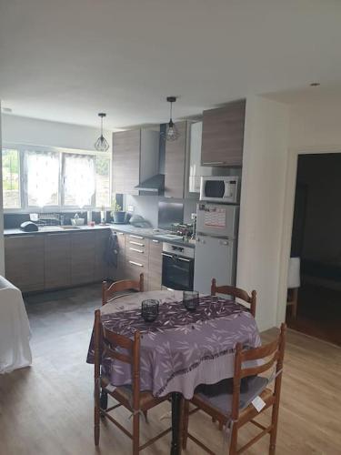 une cuisine avec une table, deux chaises et une table. dans l'établissement Petite maison individuelle à 30min de Paris, à Brétigny-sur-Orge