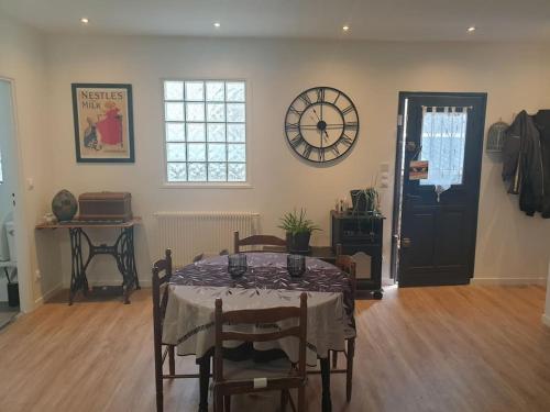 a dining room with a table and a clock on the wall at Petite maison individuelle à 30min de Paris in Brétigny-sur-Orge
