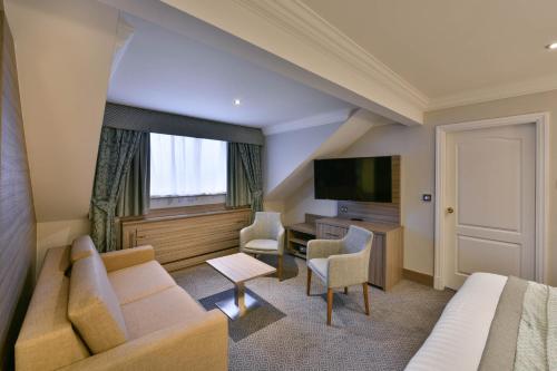 a hotel room with a couch and a television at Holiday Inn - Manchester - Oldham by IHG in Manchester